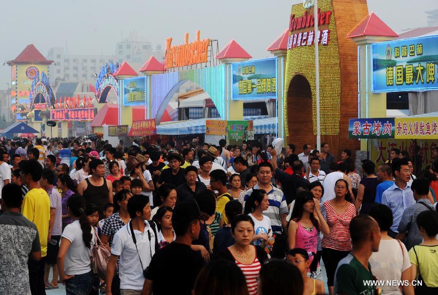 Tourists enjoy themselves at the 21st International Beer Festival at the beer city in Qingdao, east China's Shandong Province, Aug. 14, 2011. Qingdao's 21st International Beer Festival, a 16-day event, opened on Saturday, in which over 200 kinds of beer products of 20 well known brands are presented for beer lovers. A total of 77 tons of beer were sold during its first day. [Xinhua/Li Ziheng]