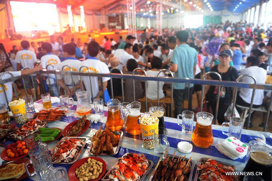 Tourists enjoy themselves at the 21st International Beer Festival at the beer city in Qingdao, east China's Shandong Province, Aug. 14, 2011. Qingdao's 21st International Beer Festival, a 16-day event, opened on Saturday, in which over 200 kinds of beer products of 20 well known brands are presented for beer lovers. A total of 77 tons of beer were sold during its first day. [Xinhua/Li Ziheng]