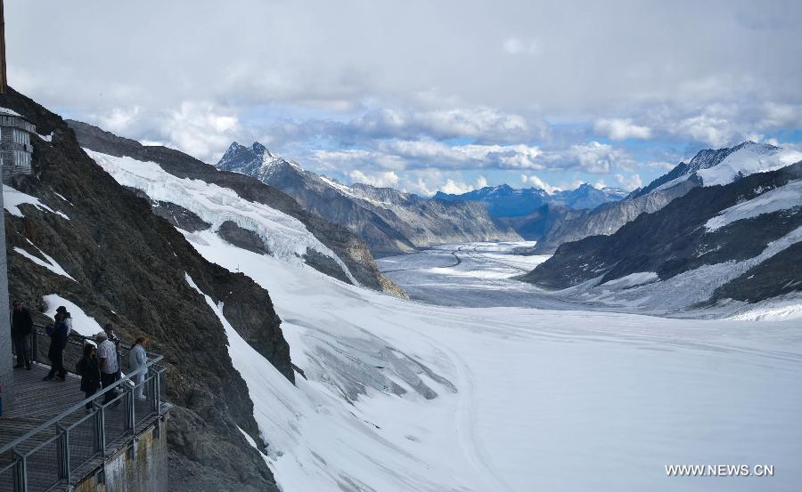 Tourists enjoy the view of icy mountains at the Jungfraujoch, the highest railway station in Europe, in the Valais Alps, Switzerland on Aug. 13, 2011. Taking the cog train up across mountains and finally getting to its last stop the Jungfraujoch is Switzerland's most popular mountain railway excursion. (Xinhua/Yu Yang) 