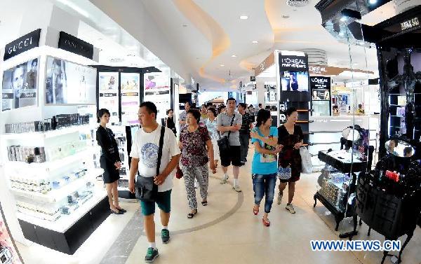 Customers go shopping at a tax-free shop in Sanya, south China's Hainan Province, Aug. 12, 2011. 