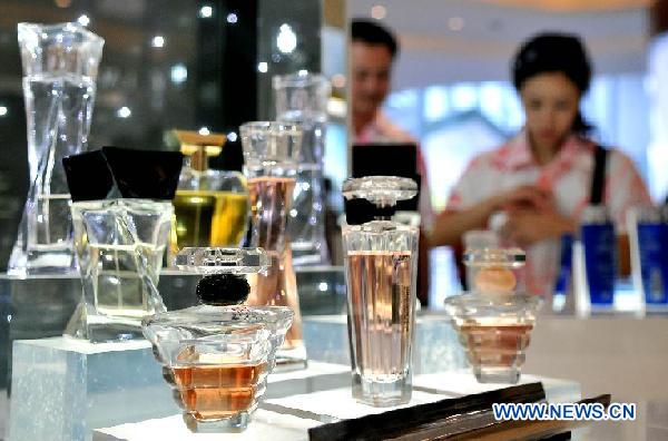 Customers choose perfumes at a tax-free shop in Sanya, south China's Hainan Province, Aug. 12, 2011. 