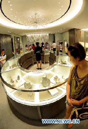 Customers select jewels at a tax-free shop in Sanya, south China's Hainan Province, Aug. 12, 2011. 