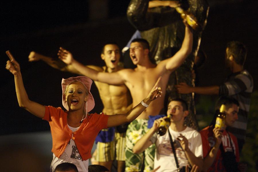 People enjoy the atmosphere during the 51st Guca Trumpet Festival in western village Guca of Serbia on Aug. 13, 2011. About half million visitors came to Guca this year to attend the biggest trumpet festival in the world. (Xinhua/Marko Rupena)