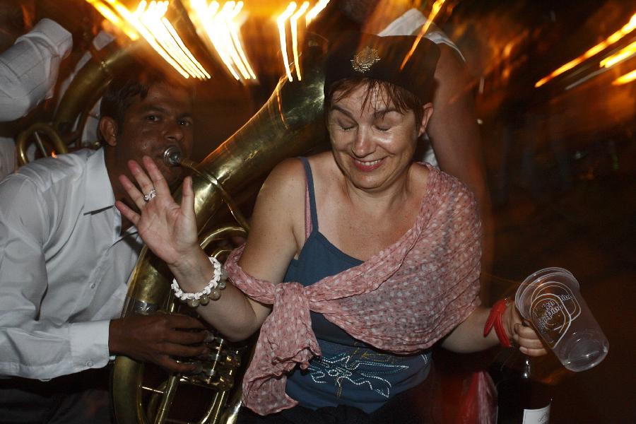 A woman enjoys the atmosphere during the 51st Guca Trumpet Festival in western village Guca of Serbia on Aug. 13, 2011. About half million visitors came to Guca this year to attend the biggest trumpet festival in the world. (Xinhua/Marko Rupena)
