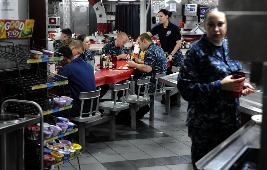 Soldiers have food in the dining room on the USS Ronald Reagan Aircraft Carrier in Hong Kong, Aug. 13, 2011. The USS Ronald Reagan Aircraft Carrier and its three support ships arrived in Hong Kong on Friday for a four-day port visit, which is its fourth visit here. [Chen Xiaowei/Xinhua] 