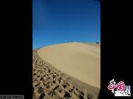 Photo taken on Aug. 25, 2011 shows the adjacent Mingsha Mountain Dunes (Singing-Sand Dunes) in Dunhuang City, northwest China's Gansu Province.  The famous tourist attraction Mingsha Mountain Dunes, which is six kilometers south of Dunhuang City, has moved towards Yueya Spring for about 8 to 10 meters in the past 15 years due to the geological movement, according to the latest statistics. [China.org.cn]
