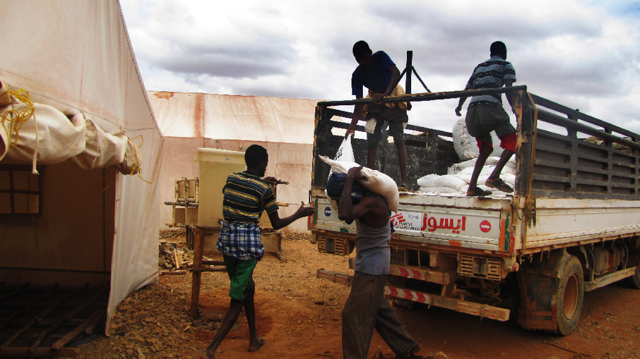 Unloading sacks of flour at Kobe camp. Families of malnourished children receive additional food (flour and oil) and a blanket. [Sisay Zerihun/MSF]