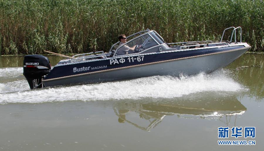 Russian President Medvedev sails on a boat during their holiday on Tuesday. Prime Minister Putin was also present. 