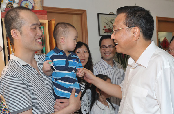 Vice-Premier Li Keqiang chats with Yeung Sau-goi as he meets his family in Lam Tin, Hong Kong, on Aug 16, 2011. [Photo/China Daily]