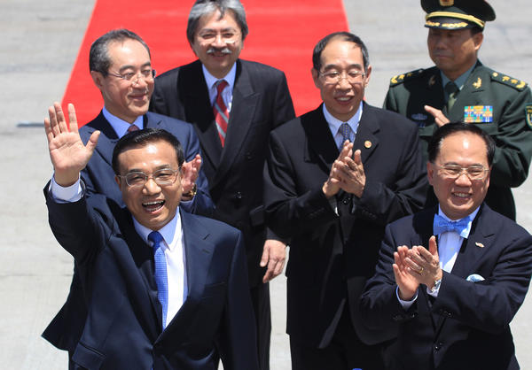 Vice-Premier Li Keqiang waves to crowds upon his arrival at Hong Kong airport on Tuesday. He was greeted by senior officials of Hong Kong led by Chief Executive Donald Tsang (first right). [Photo/China Daily]