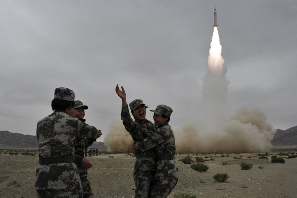 Chen Qin and her colleagues cheer after they launch a missile. The exercise was part of their final training test. [Photo/Xinhua]