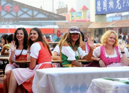 German tourists enjoy themselves at the 21st International Beer Festival at the beer city in Qingdao, east China&apos;s Shandong Province, Aug. 14, 2011. Qingdao&apos;s 21st International Beer Festival, a 16-day event, opened on Saturday, in which over 200 kinds of beer products of 20 well known brands are presented for beer lovers. A total of 77 tons of beer were sold during its first day. [Li Ziheng/Xinhua]