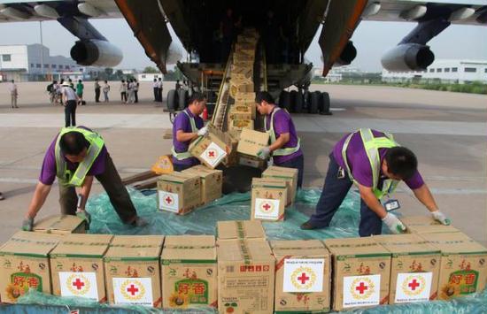 Workers help load relief materials for Libya onto a plane at an airport in Tianjin, August 17, 2011.