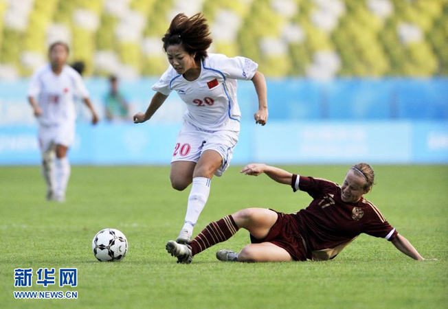 Chinese player Xing Wei (L) breaks through with the ball during the 1/4 final of women's soccer at the 26th Summer Universiade, Shenzhen, South China's Guangdong Province, on August 17, 2011. China defeat Russia by 4:1. (Photo by Chen Yehua) 