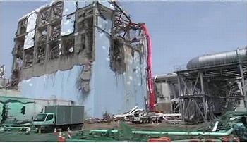 Water is sprayed by a concrete pumping truck to cool the spent fuel pool of Fukushima Daiichi Unit 4. The green color in the foreground is dust inhibitor. May 6, 2011. [TEPCO] 