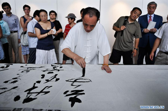 Chinese calligraphist Chen Jinchun performs at the opening ceremony of his exhibition 'Charm of the Chinese Calligraphy' in Palais des Nations, Geneva, Switzerland, Aug. 18, 2011.