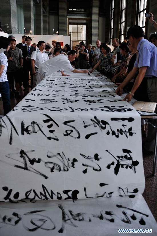 Chinese calligraphist Chen Jinchun performs at the opening ceremony of his exhibition 'Charm of the Chinese Calligraphy' in Palais des Nations, Geneva, Switzerland, Aug. 18, 2011. 