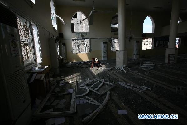 A Palestinian man looks over the damage in Bin Zayed mosque after an Israeli air strike in Gaza August 19, 2011. [Xinhua]