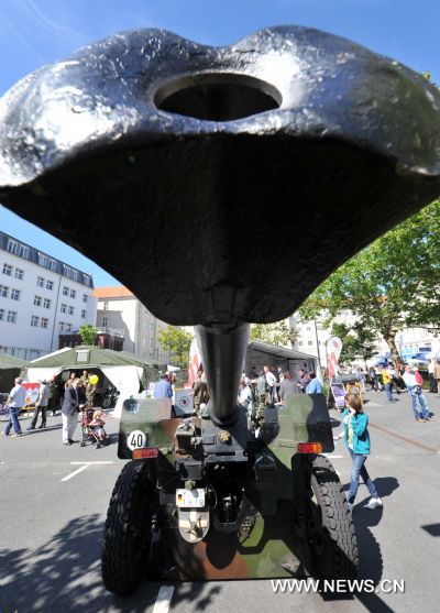 A girl looks at a saluting artillery in the German Defense Ministry during the government open day event in Berlin, Germany, Aug. 20, 2011. [Xinhua/Ma Ning]