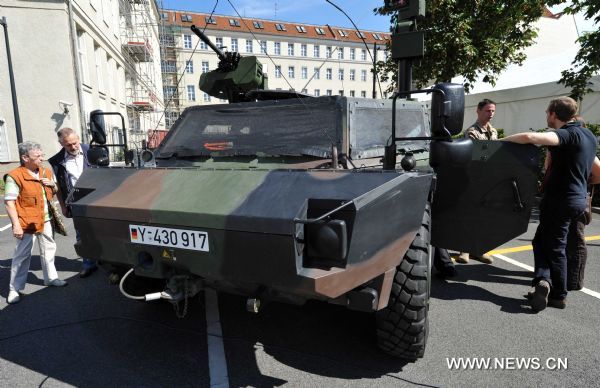 Visitors look at an armored vehicle in the German Defense Ministry during the government open day event in Berlin, Germany, Aug. 20, 2011. [Xinhua/Ma Ning]