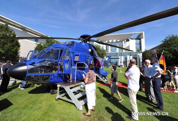 People look at the Prime Minister's helicopter in the German Prime Minister office during the government open day event in Berlin, Germany, Aug. 20, 2011. [Xinhua/Ma Ning] 