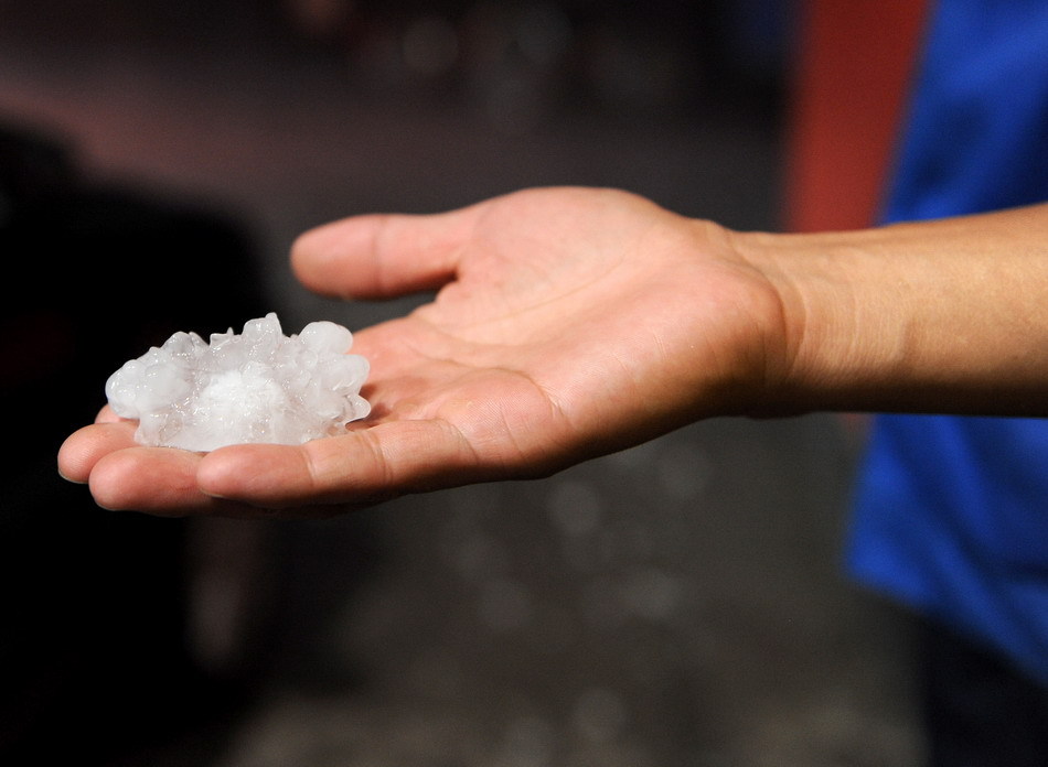 A citizen holds hailstones in Shenyang, northeast China&apos;s Liaoning Province, Aug. 21, 2011. A hail storm hit Shenyang Sunday evening. [Xinhua]