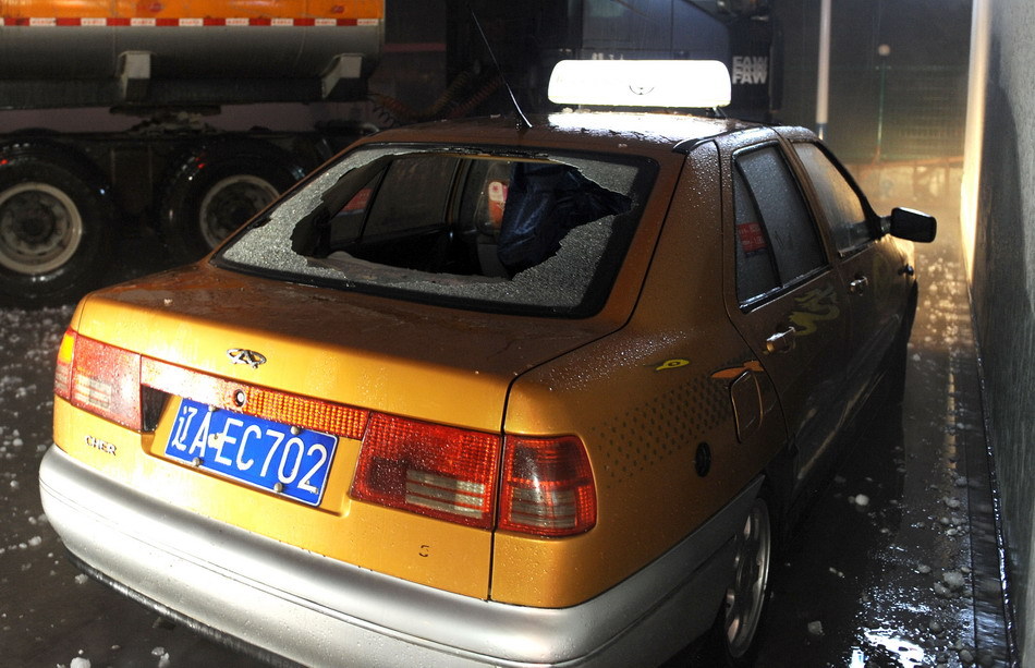 A taxicab damaged by hailstones is seen in Shenyang, northeast China's Liaoning Province, Aug. 21, 2011. A hail storm hit Shenyang Sunday evening. [Xinhua]