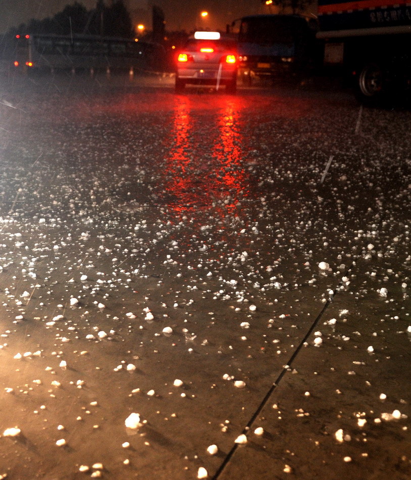 Hailstones are seen on the road in Shenyang, northeast China&apos;s Liaoning Province, Aug. 21, 2011. A hail storm hit Shenyang Sunday evening. [Xinhua]