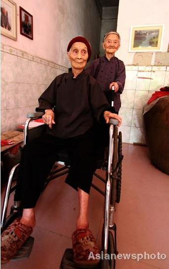 After sharing a husband for 69 years, Huang Magan (right), 106, holds the wheel chair of her 103-year-old companion Huang Maxue at their home in Ping'an village, Bama Yao autonomous county, South China's Guangxi Zhuang autonomous region, August 21, 2011. 