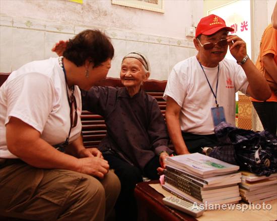 Huang Magan (center), 106, talks to guests at her home in Ping'an village, Bama Yao autonomous county, South China's Guangxi Zhuang autonomous region, August 21, 2011.