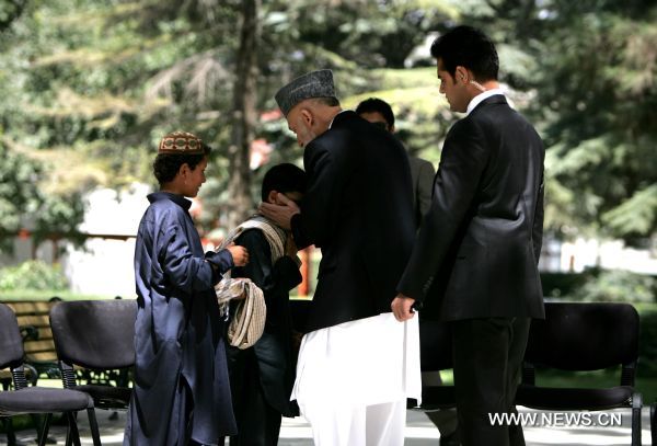 Afghan President Hamid Karzai embraces a child suicide bomber during a ceremony to mark the release of 20 child bombers at presidential palace in Kabul, Aug. 24, 2011. On the eve of Muslims&apos; big festival -- Eid-ul-Fiter -- which marks the end of Ramadan or Muslim fasting month, President Karzai ordered the authorities to release all 20 child bombers and let them join their families all over Afghanistan. Taliban insurgents often track children to carry out suicide attacks on Afghan and NATO forces in the insurgency-hit country.(Xinhua/Ahmad Massoud Pool) (qs) 