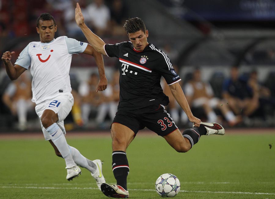 FC Zurich's (FCZ) Heinz Barmettler (L) tries to defend as FC Bayern Munich's Mario Gomez kicks the ball to score the first goal during their Champions League play-off second leg soccer match in Zurich August 23, 2011. (Xinhua/Reuters Photo)