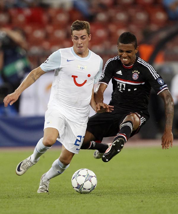 FC Zurich's (FCZ) Marco Schoenbaechler (L) is challenged by Luiz Gustavo of FC Bayern Munich during their Champions League play-off second leg soccer match in Zurich August 23, 2011. (Xinhua/Reuters Photo)