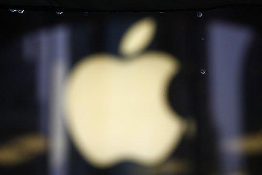 Raindrops are seen in front of an Apple logo outside an Apple retail store in Shanghai August 25, 2011.
