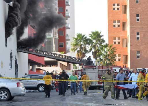 Firefighters carry an unidentified person on stretcher out of the Casino Royale in Monterrey, Mexico, Thursday Aug. 25 2011.