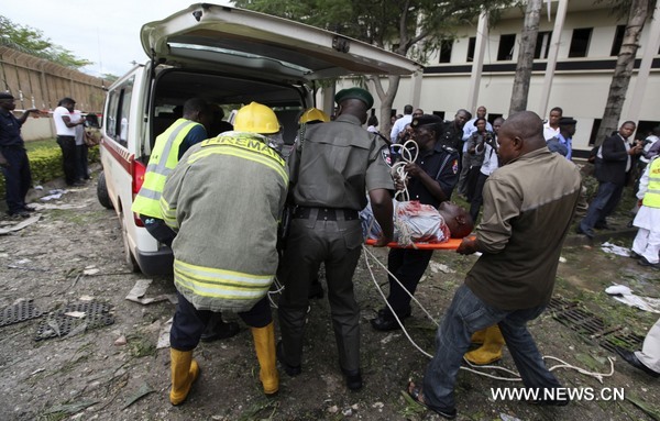 A victim of a bomb blast ripped through the United Nations offices in the Nigerian capital of Abuja is loaded into an ambulance, August 26, 2011, after a car rammed into the building, and witnesses said they had seen a number of dead bodies being carried from the site. [Xinhua/Reuters]