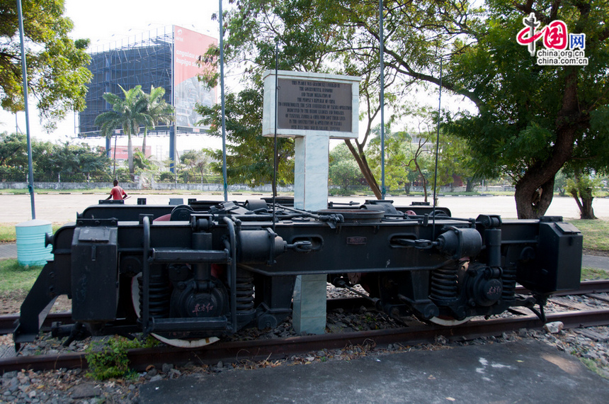 Part of a train undercarriage is placed in the square at the Dar es Salaam central railway station. The train undercarriage is to commemorate the 25th anniversary of Tazara operation (July 19, 2001), and is to dedicated to the heroic leaders and workers of Tazara. [Maverick Chen / China.org.cn]