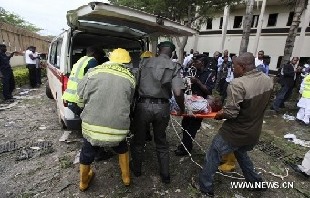 A victim of a bomb blast ripped through the United Nations offices in the Nigerian capital of Abuja is loaded into an ambulance, August 26, 2011, after a car rammed into the building, and witnesses said they had seen a number of dead bodies being carried from the site. [Xinhua/Reuters]