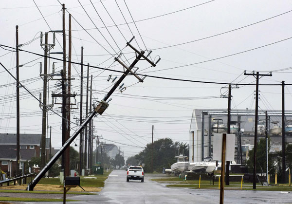 A utility pole leans over the street from winds off the back end of Hurricane Irene as the storm came ashore near Atlantic Beach, North Carolina, August 27, 2011. [China Daily via Agencies]