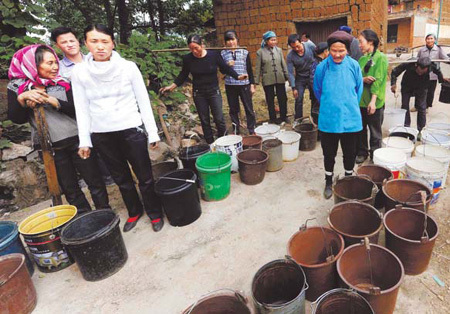 Residents in Qingshan village in Qujing city, Southwest China's Yunnan province, wait for trucks carrying water on Thursday. More than 3.2 million people in Qujing are running short of drinking water after the city was hit by its most severe drought since 1961. [Yang Zongyou/Xinhua]