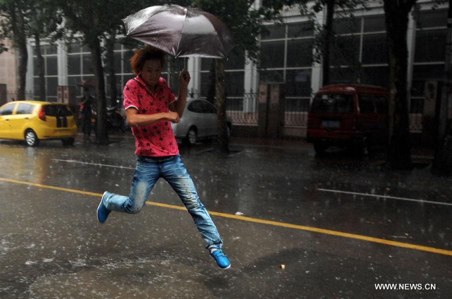 A citizen jumps on a waterlogged street in Jinan, capital of east China's Shandong Province, Aug. 27, 2011. A heavy rainstorm hit Jinan on Saturday. [Guo Xulei/Xinhua]