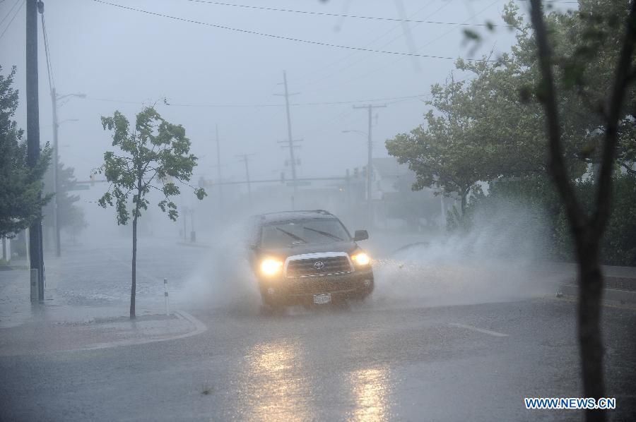 Photo taken on Aug. 27 shows a vehicle runs through floodwaters caused by Hurricane Irene in Ocean City, Maryland, the United States. The Hurricane Irene hits the Ocean City of Maryland on Saturday. [Zhang Jun/Xinhua]