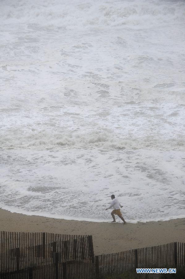 Photo taken on Aug. 27 shows a man on beach as Hurricane Irene approaches, in Ocean City, Maryland, the United States. The Hurricane Irene hits the Ocean City of Maryland on Saturday. [Zhang Jun/Xinhua]