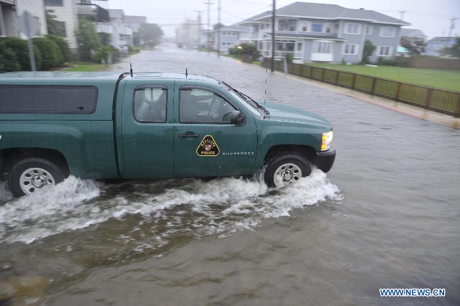 Photo taken on Aug. 27 shows a police car plows through floodwaters caused by Hurricane Irene in Ocean City, Maryland, the United States. The Hurricane Irene hits the Ocean City of Maryland on Saturday. [Zhang Jun/Xinhua]