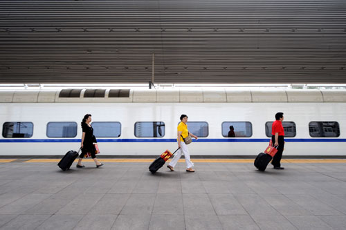 Passengers board a bullet train at Taiyuan Railway Station in Taiyuan, north China's Shanxi Province, Aug. 28, 2011. China started to implement a new operation plan for all bullet trains across the country on Sunday, rescheduling trains to run at slower speeds over safety concerns. [Yan Yan/Xinhua]