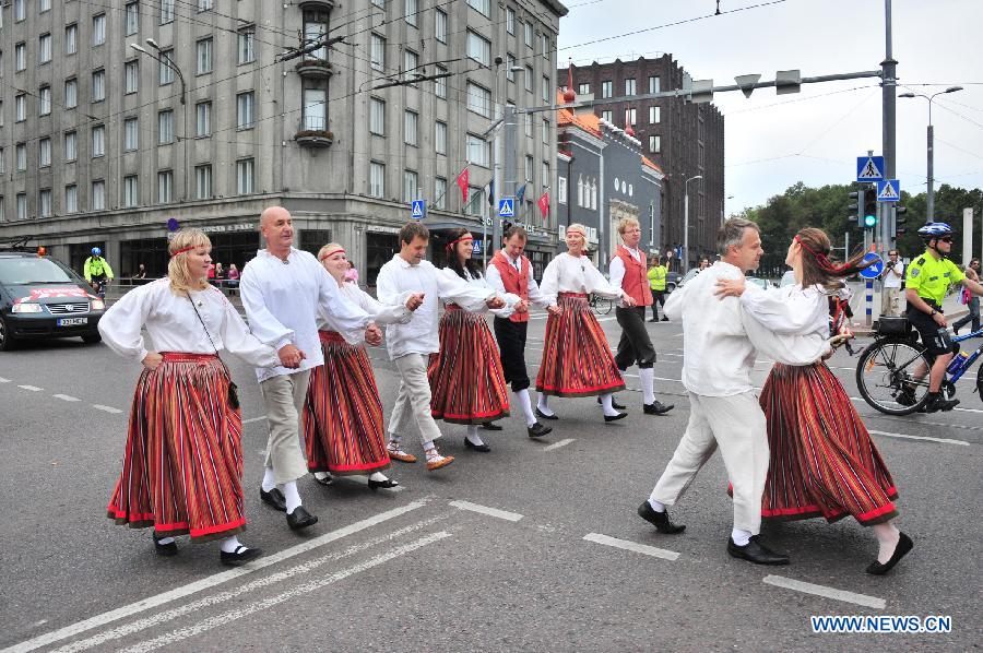 Estonian amateur folk dancers in folk costumes dance while walking in Talinn, capital of Estonia, Aug. 28, 2011. About 7,000 amateur folk dancers took park in the eight-day-and-night 1,000-km marathon dance in Estonia that ended on Sunday. [Xinhua/Victor]