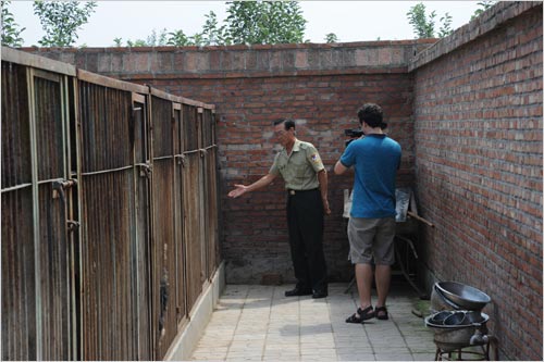 Officer Hao Wuxing explains to CRI Video Journalist Jonathan Alpart about the type of dogs that are trained at the Beijing Police Dog Camp in Changping on August 19th, 2011. [Photo: CRIENGLISH.com]