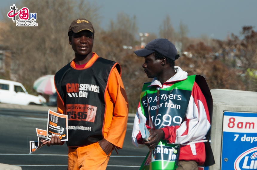 Black people are still in lower social strata in South Africa. The photo shows salesmen trying to promote their products to drivers when the vehicles are waiting for traffic light to change at a crossroad. [Maverick Chen / China.org.cn]
