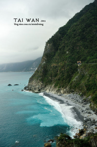 The Pacific Ocean is visible from the highway above the mountains.