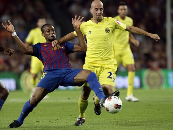 Barcelona's Seydou Keita (L) and Villarreal's Borja Valero challenge for the ball during their Spanish first division soccer match at Nou Camp stadium in Barcelona August 29, 2011. (Xinhua/Reuters)